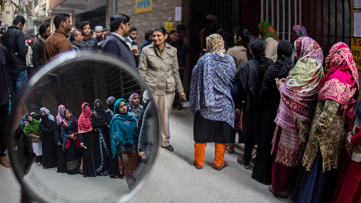 Voters queue up outside a polling station during the Delhi assembly elections, 8 February 2020