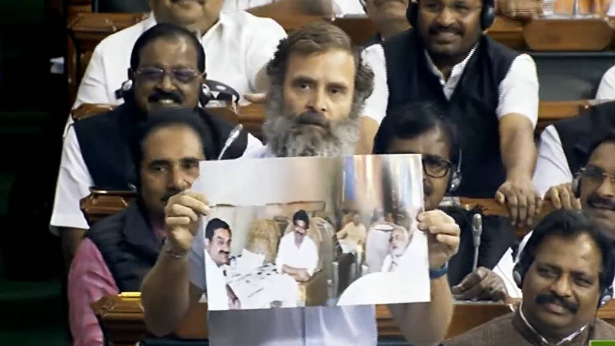 Rahul Gandhi displays a photo of PM Modi with businessman Gautam Adani in the latter's private jet