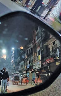 Image shows the city in a car's rear-view mirror (Photo: Akhil Katyal)