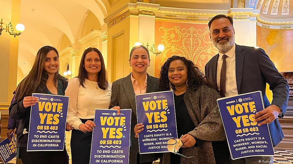 Thenmozhi Soundararajan with other activists holding "Vote Yes" posters