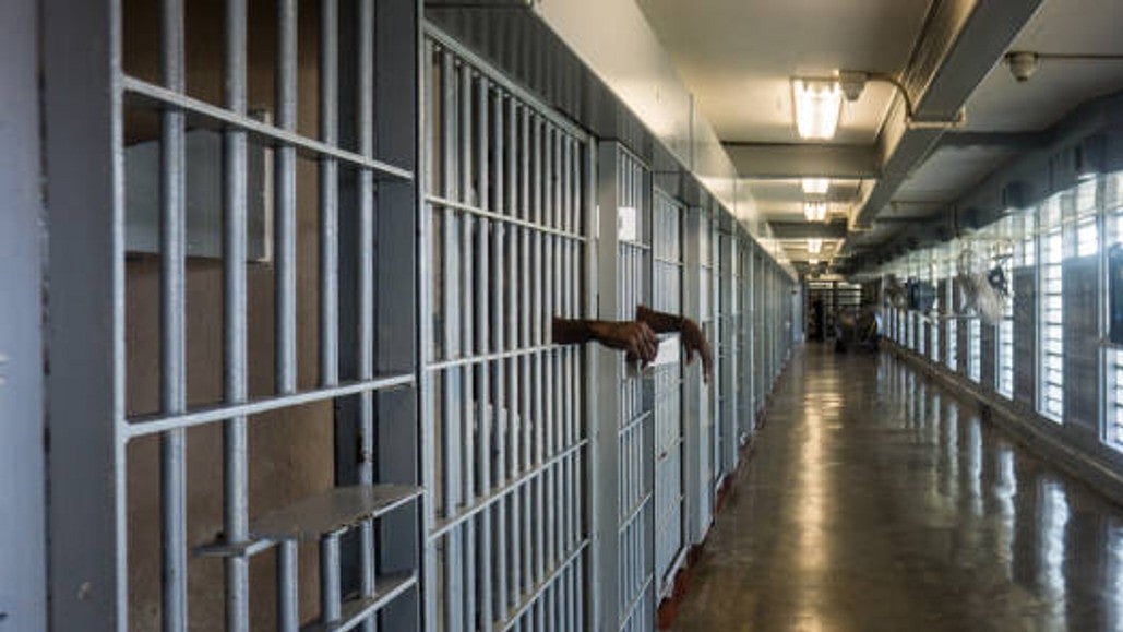 A prisoner's hand visible from their prison cell railings (Getty Images)