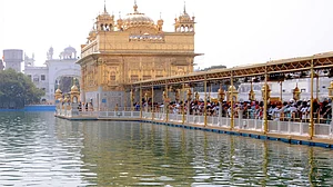 Sikh Devotees wait to offer prayers at the Golden Temple on the occasion of Baisakhi, in Amritsar, on Friday, April 14, 2023. (Photo: Pawan sharma/IANS)
