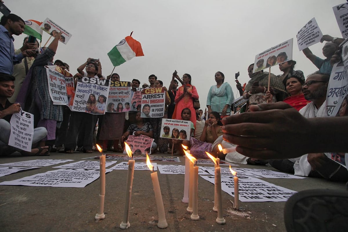 Protesters standing around lit candles (NH Photos by Vipin)