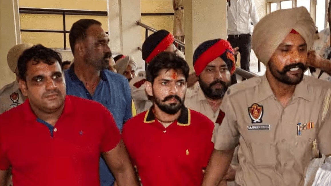 Lawrence Bishnoi being escorted by the police (Photo Courtesy: @NBCHINDI/Twitter)