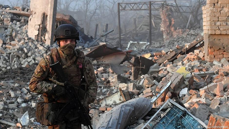 A Russian soldier standing amidst rubble (DW)