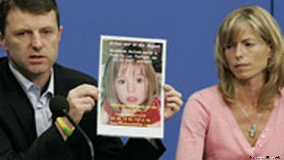 Parents of Madeleine McCann holding up a her photo (DW)