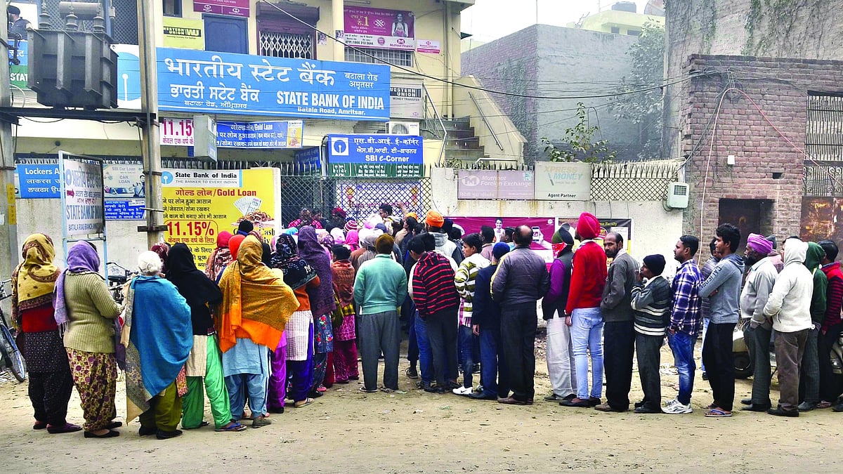 People queue up outside an SBI branch in Punjab’s Amritsar to withdraw some cash on 29 December 2016 following the demonetisation