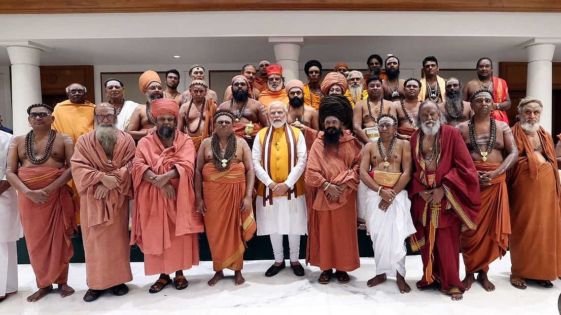 PM Modi at his residence with the adheenams of the mutt from which the much-debated sengol originated (finance minister Nirmala Sitharaman stands to a side, not seen in the frame) (photo courtesy PMO, GOI)