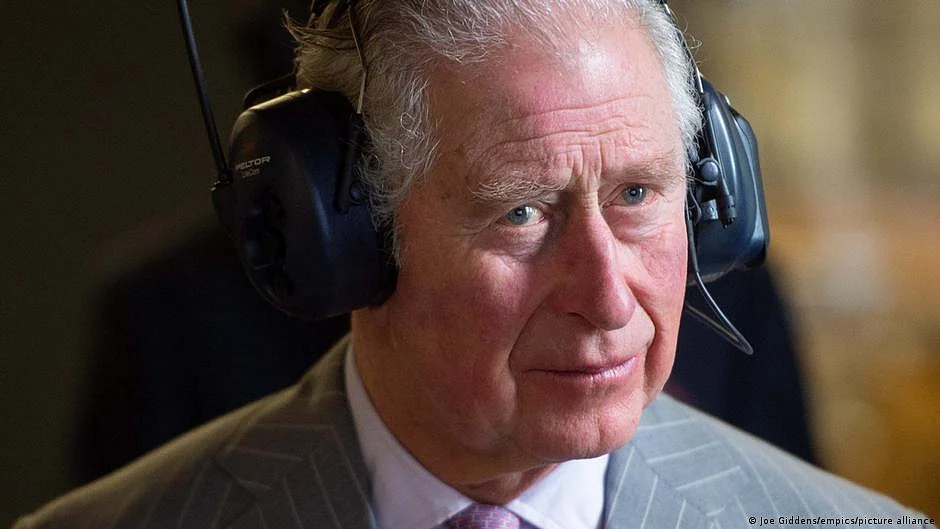 King Charles III wearing headphones (DW)