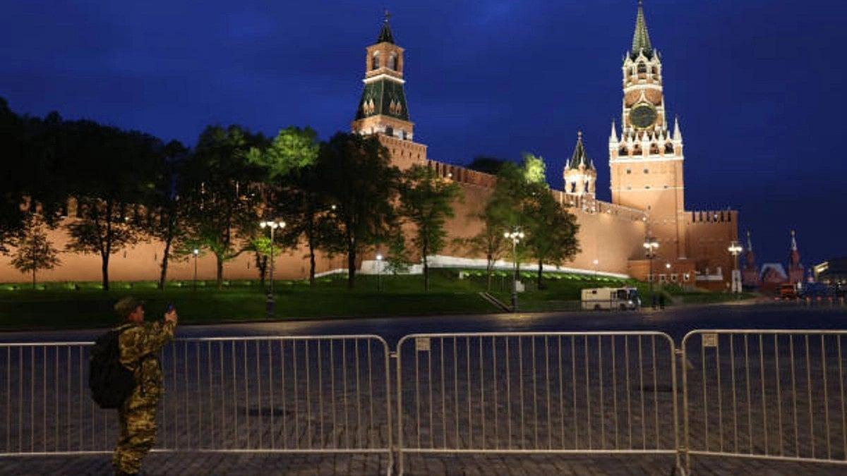 A man in military unoform takes a photo of the Red Square in front of the Kremlin (Getty Images)