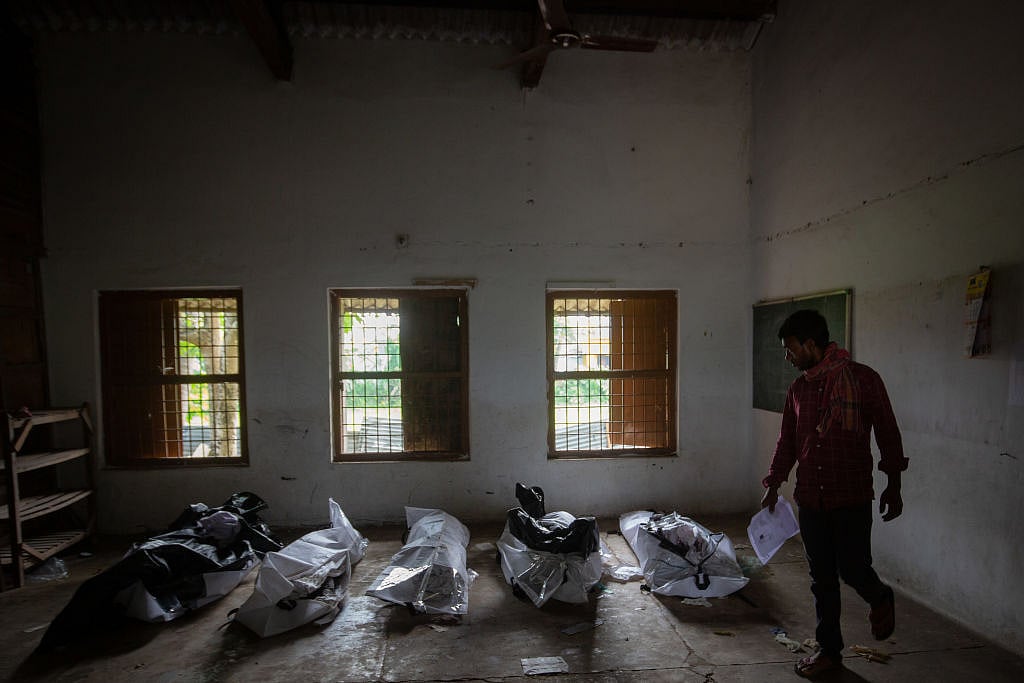 A man attempts to identify a missing relative among unidentified dead bodies of train accident victims, kept inside a school in Bahanaga village, 4 June (Photo: Getty Images)  