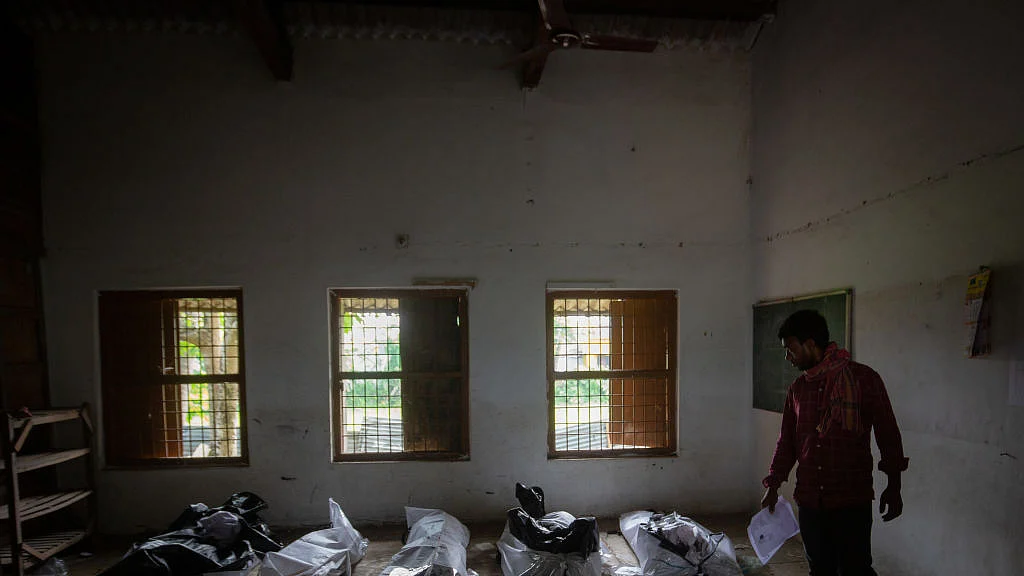 A man attempts to identify a missing relative among unidentified dead bodies of train accident victims, kept inside a school in Bahanaga village, 4 June (Photo: Getty Images)  