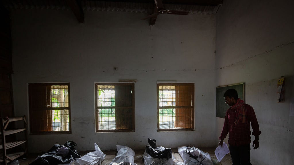 A man attempts to identify a missing relative among unidentified dead bodies of train accident victims, kept inside a school in Bahanaga village, 4 June (Photo: Getty Images)  