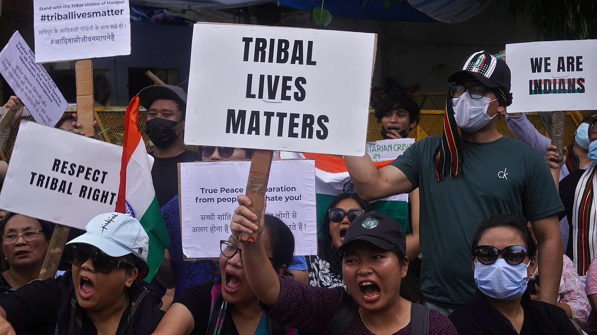 Members of the Kuki and Zo tribes hold Indian flags and placards during a protest amid ongoing ethnic violence in India's northeastern Manipur state, in New Delhi, India on May 31, 2023. (photo: Mayank Makhija/NurPhoto via Getty Images)