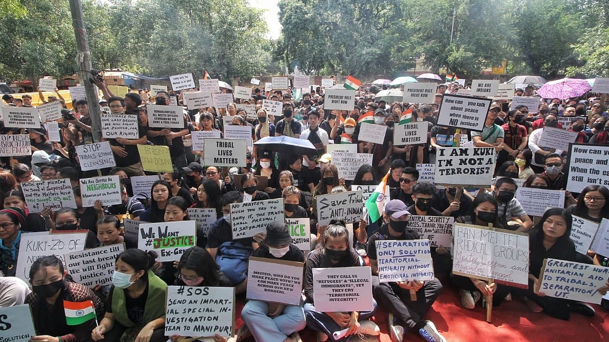 Members of the Kuki tribes hold banners & Indian flags while protesting against the killing of tribals in their home state Manipur, in New Delhi (photo: Vipin/National Herald)