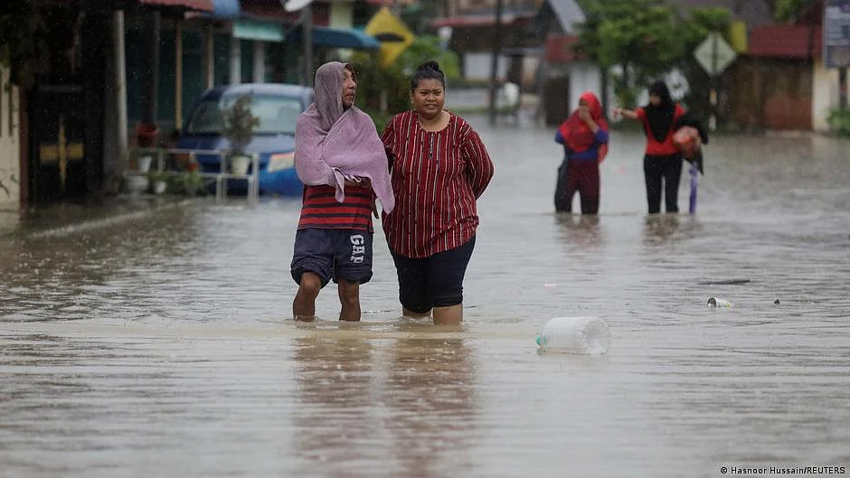 People standing in knee-deep water during a flood (photo: DW)