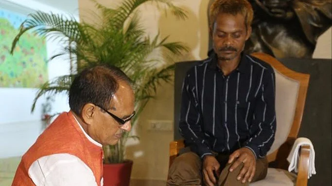 Madhya Pradesh CM Shivraj Singh Chouhan with Darshan Rawat, the Adivasi from the viral video where he was urinated upon by a BJP party member (Photo: Twitter/@love_liv_laf)