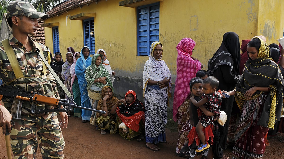 Security personel stand on gaurd as women are standing in line at polling booth to vote during second phase of West Bengal panchayat elections (Photo: Getty Images)