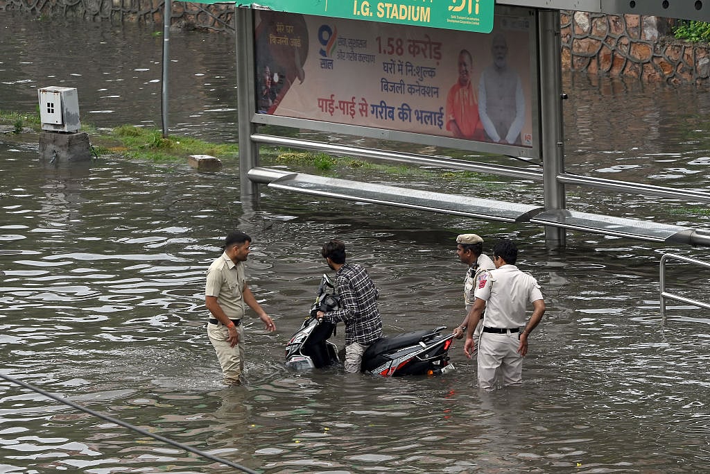 Police personnel helping a motorcyclist stuck on the flooded streets (Photo: Getty Images)