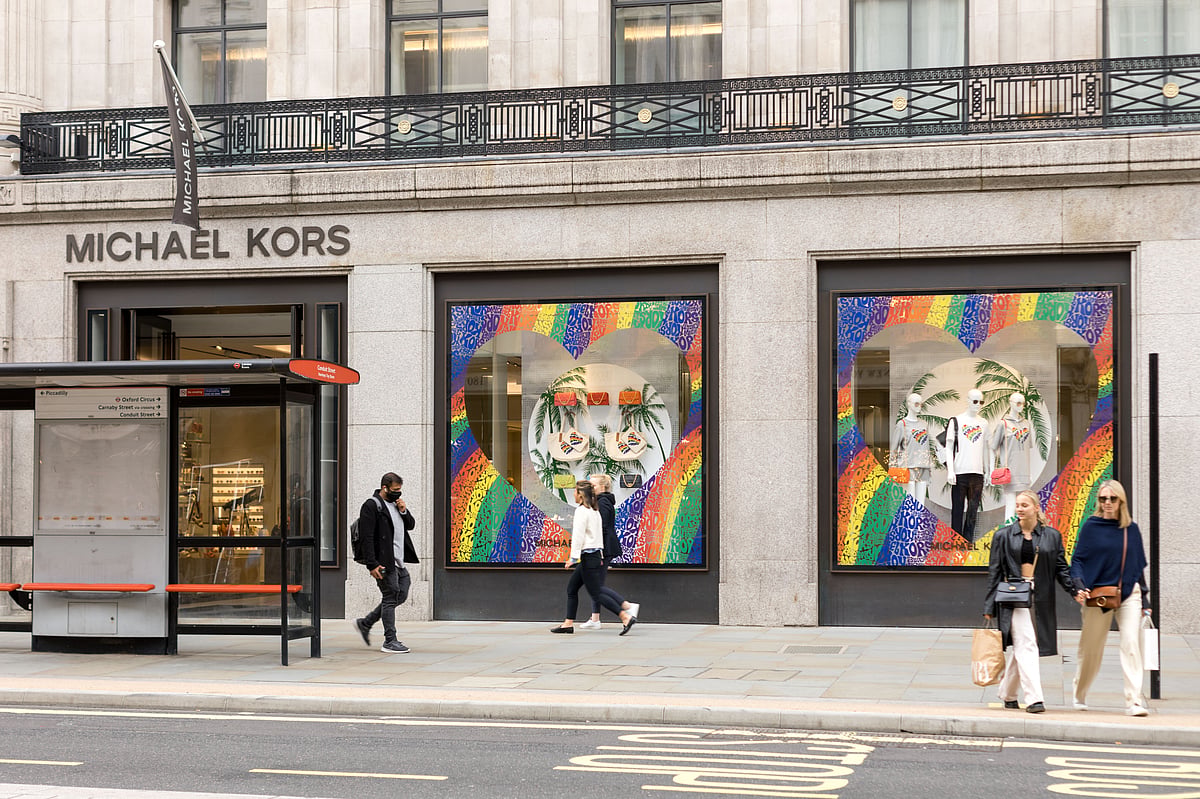 People walk past a Michael Kors decorated with rainbow colors on its windows at the Oxford Circus in London in June, 2021.