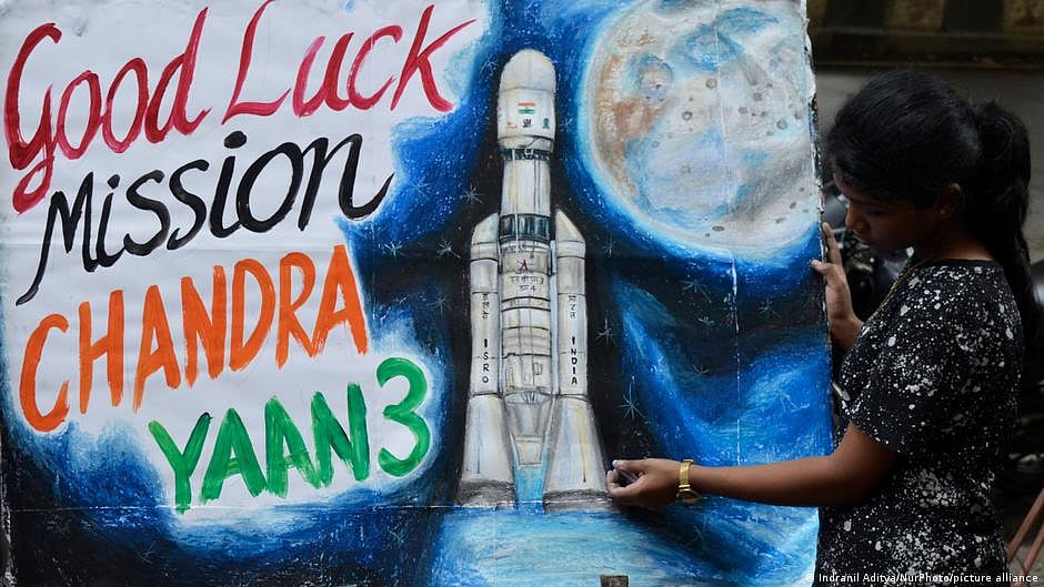 A young girl stands beside a mural that says 'Good Luck Mission Chandrayaan 3' (photo: Getty Images)