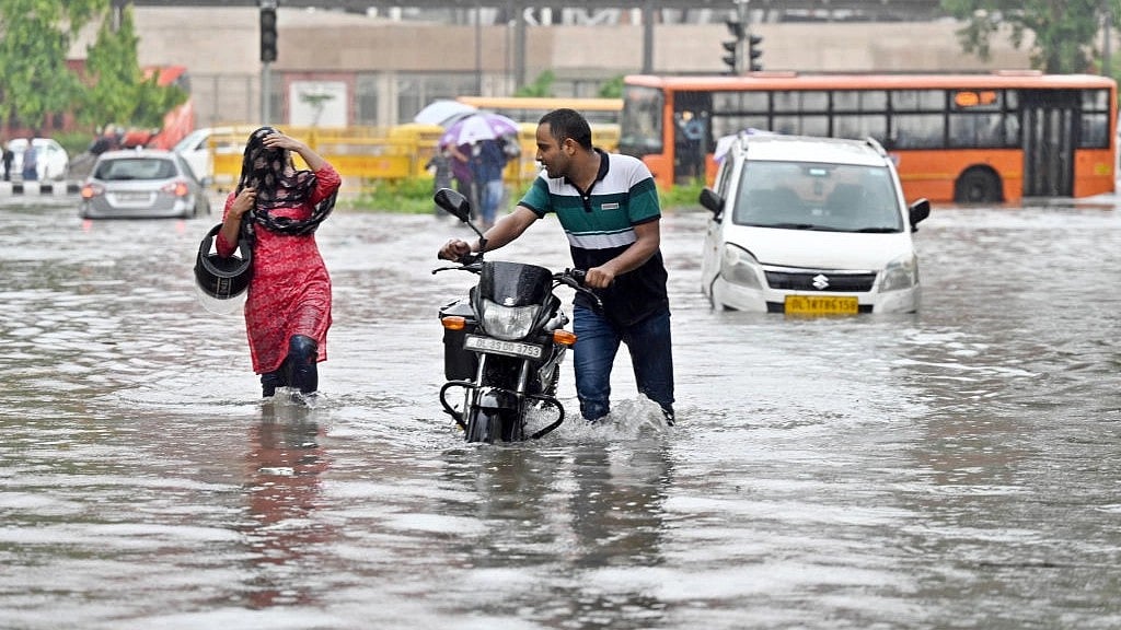 Commuters move through a water logged stretch amid heavy rains near the Supreme court of India , on July 9, 2023 in New Delhi. (photo: Getty Images)
