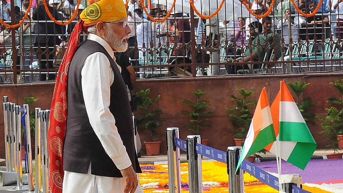 Prime Minister Narendra Modi walks past the national tricolour (photo: IANS)