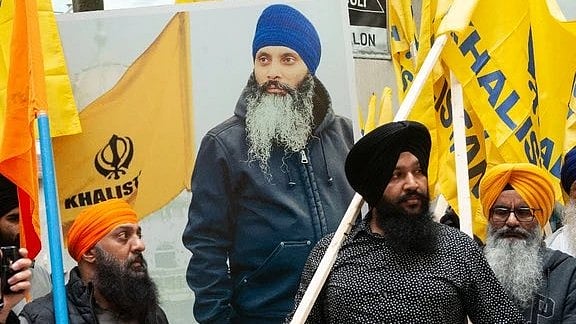 Khalistan supporters holding a poster of slain separatist leader Hardeep Singh Nijjar
