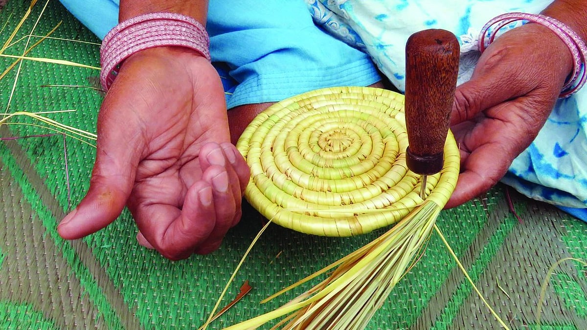an artisan shows deep gashes in her hands caused by the sharp blades of grass.