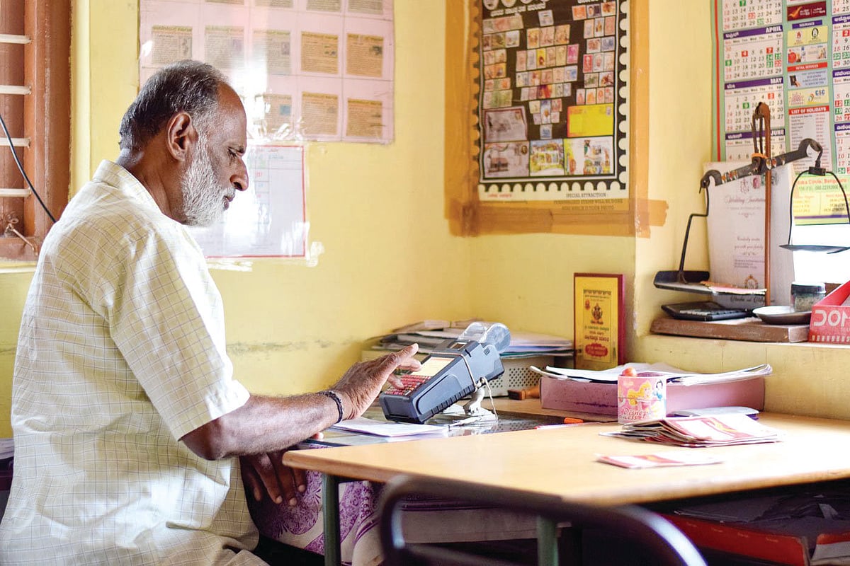 Renuka at work as a gramin dak sevak in his one-room office in Devarayapatna town in Karnataka’s Tumkur district (photo: Hani Manjunath/PARI)