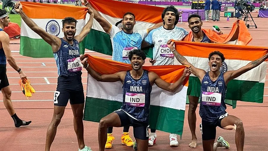 Golden moment: Neeraj Chopra (standing second from right), javelin silver medallist Kishore Jena (standing far left) pose for photographers with the gold-winning 4x400 m men's relay team (photo: @mufaddal_vohra/ X)