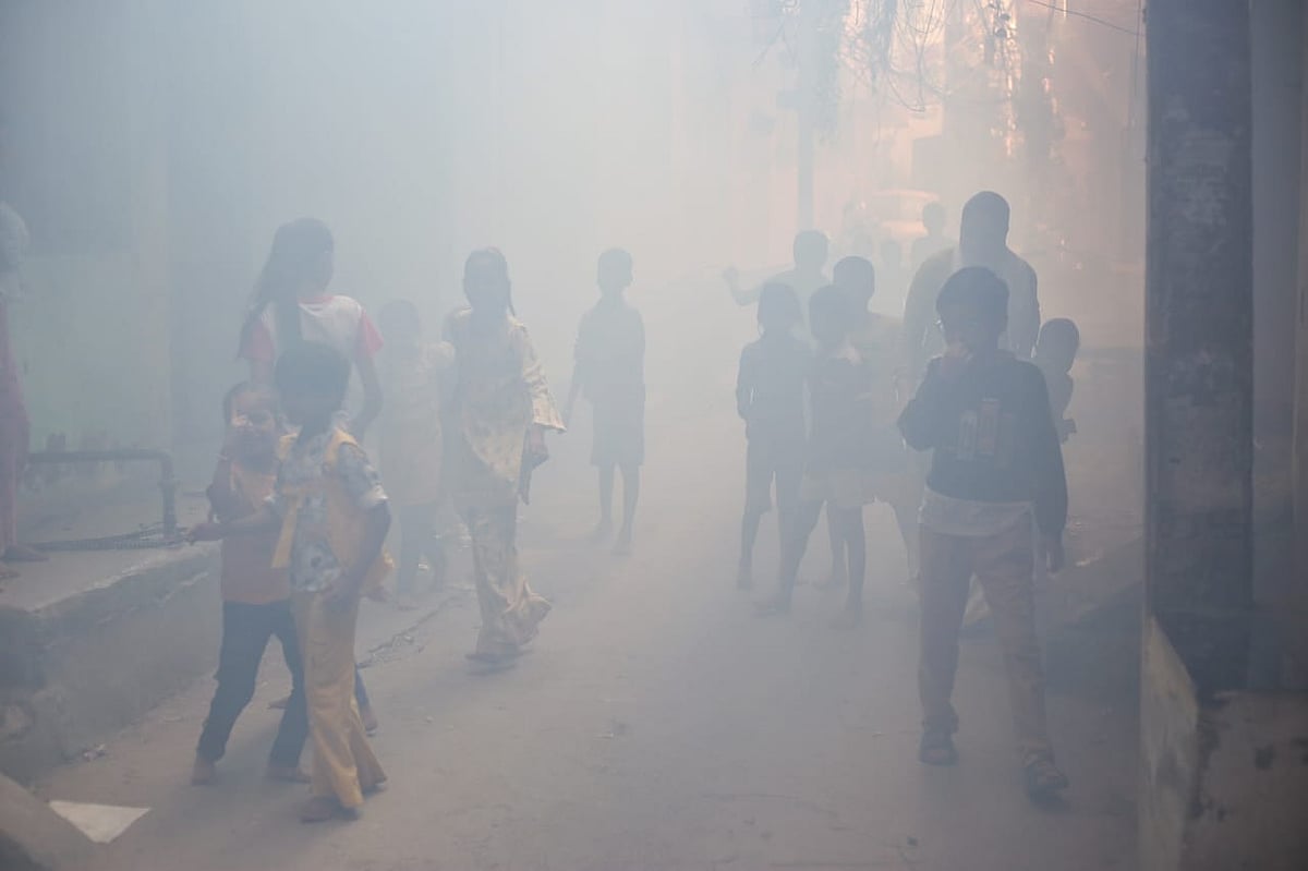 A group of kids pause their play in the middle of the fumigation drive as visibility drops. The flooding this monsoon has upped their health risk from mosquitoes (photo: Vipin/National Herald)