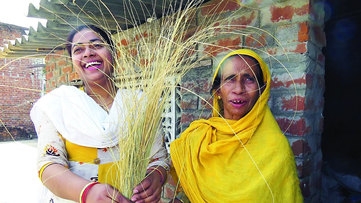 Fatima and Ayesha show a bunch of dried grass that will be woven into a beautiful showpiece (Photo: Priti David/ PARI)