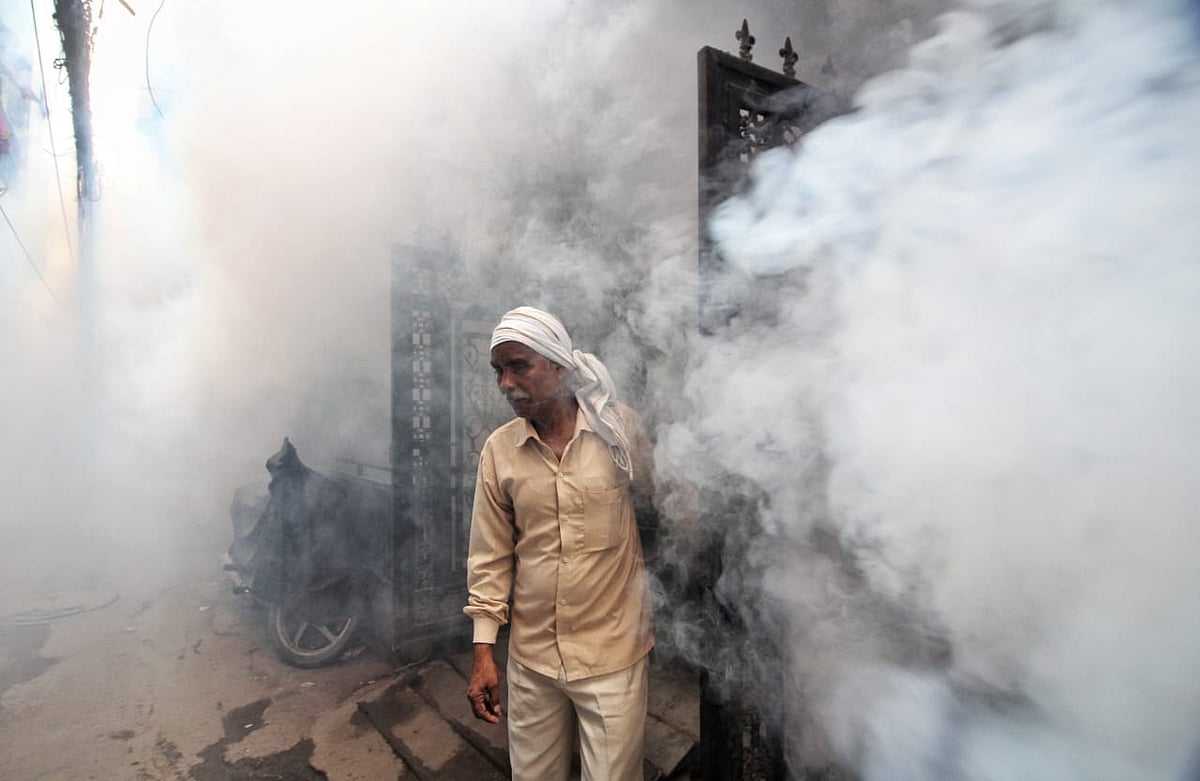 A man stands in the middle of heavy smoke. It's a small price, with Delhi NCR having crossed 3,000 cases of dengue cases this year (photo: Vipin/National Herald)