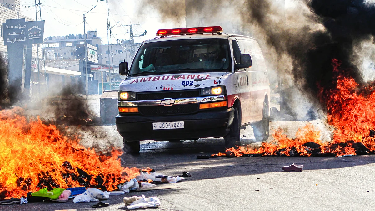 File photo of an ambulance passing through flames while transporting a Palestinian inside Gaza (photo: Getty Images)