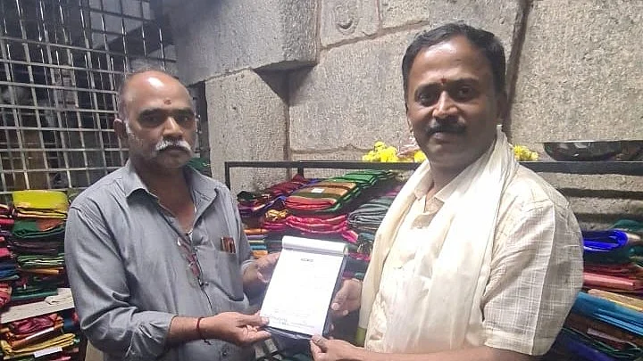 Congress MLC Dinesh Gooligowda with Chamundeshwari Temple accountant, holding up the receipt for Rs 1.18 lakh to the accountant (photo courtesy Dinesh Gooligowda)