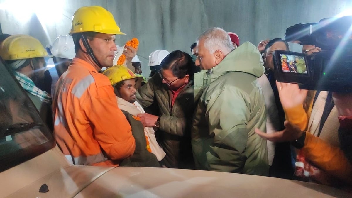 Uttarakhand chief minister Pushkar Singh Dhami and several mediapersons throng one of the first rescued workers from the Silkyara tunnel, plying him with garlands and questions (photo: IANS)