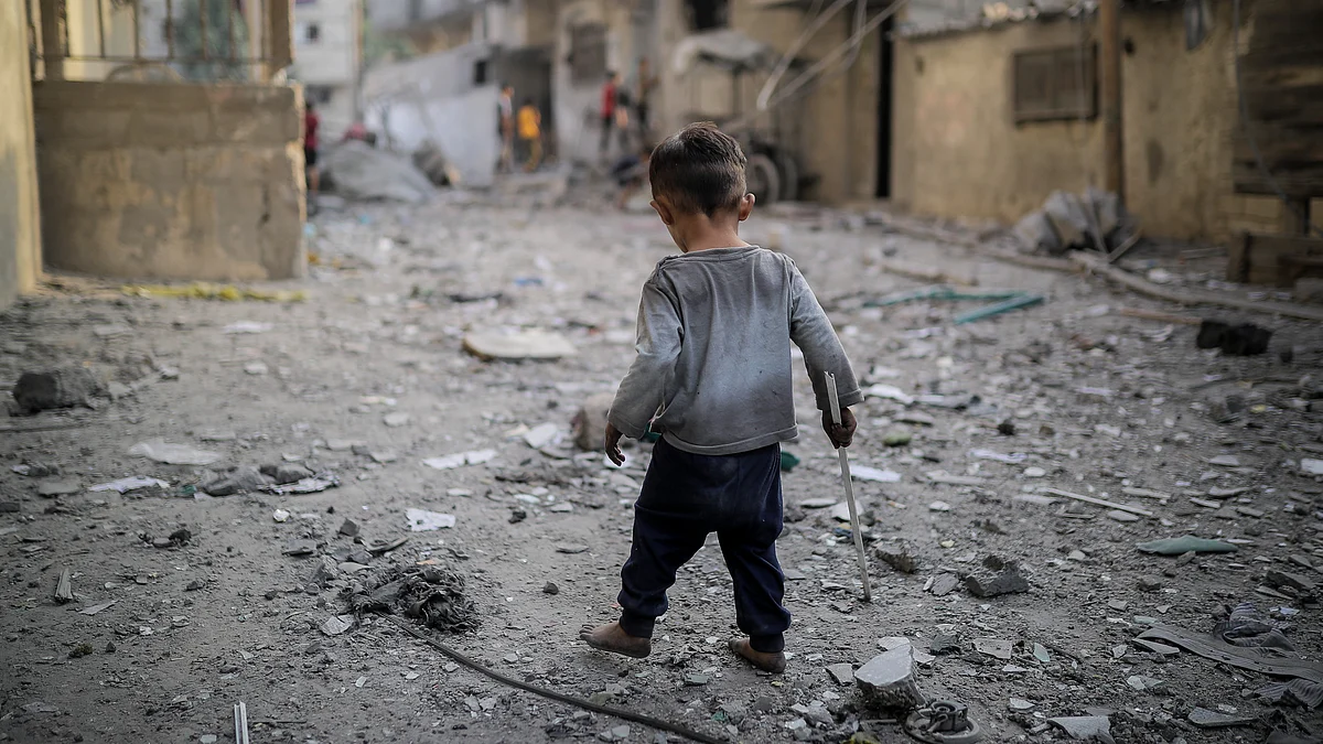 A child is seen among the rubble of destroyed buildings as Israeli airstrikes continue in Gaza (Photo:  Belal Khaled/Anadolu via Getty Images)