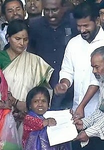 Revanth Reddy hands over the job offer to Rajini (photo: IANS)