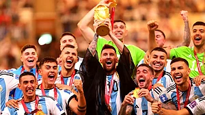 Lionel Messi holds aloft the FIFA World Cup 2022 with teammates (photo: Olympics.com)