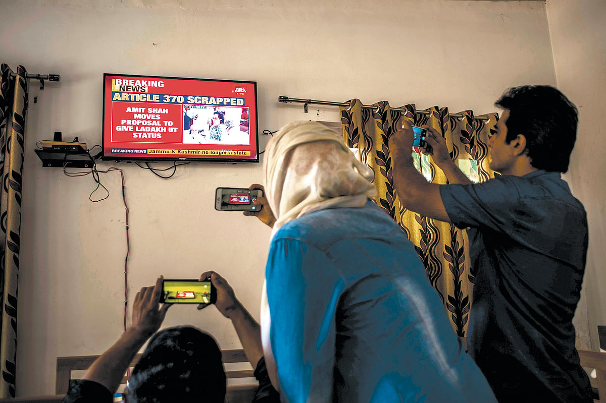 Local journalists take pictures of a TV screen as India announces the annulment of Article 370 and Article 35A on 5 August 2019, Srinagar. (Photo: Getty)