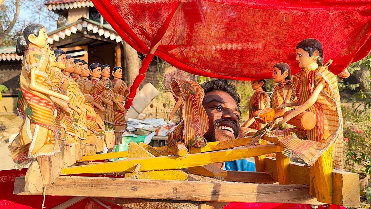 'Men' on one side, 'women' on the other, the puppets stand arrayed, with Tapan Murmu (seen behind the frame) pulling their ropes with his feet below to make them dance (photo: PARI) 