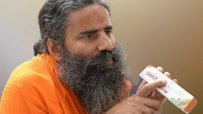 Baba Ramdev brandishes a Patanjali product. Both company and co-owners have been indicted for "false and misleading" ads (photo courtesy Patanjali Products/Facebook)
