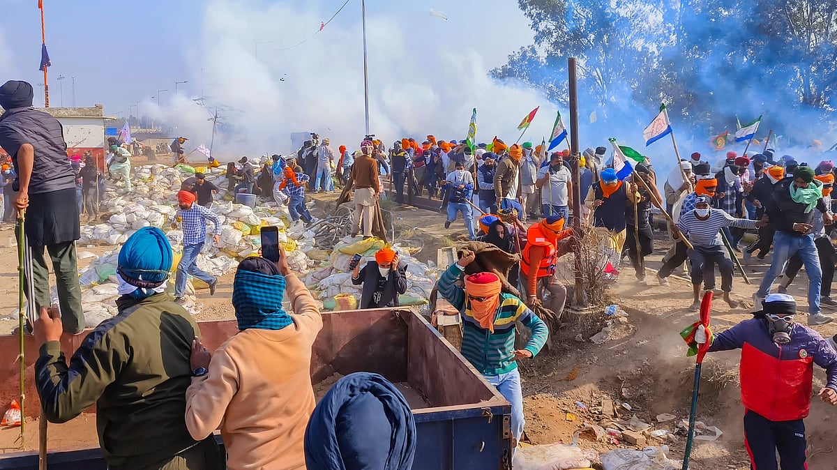 Farmers looking for cover as police fires tear gas at them in Patiala (photo: PTI)