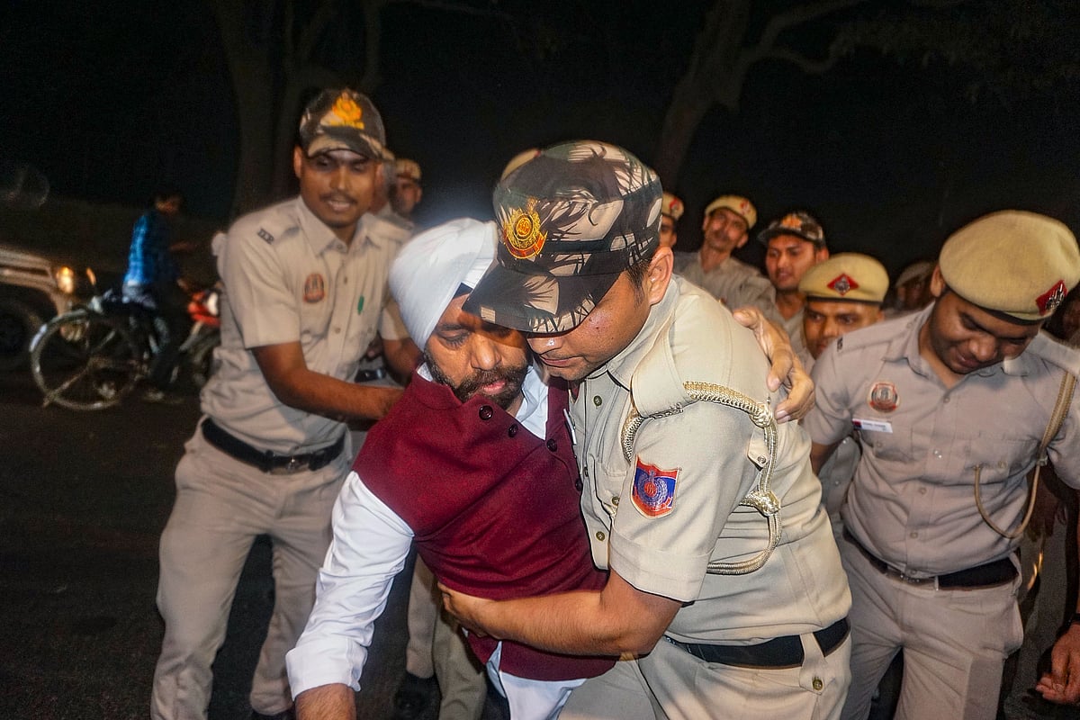 Police remove a protestor from outside Kejriwal's residence (photo: PTI)