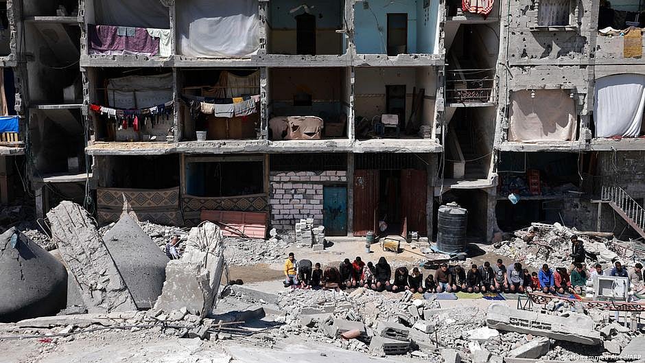 It's Ramzan. Families in Gaza pray in the streets amidst rubble, against a backdrop of ruined buildings (photo: DW)