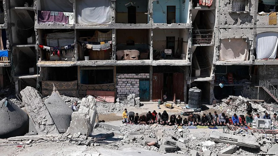 It's Ramzan. Families in Gaza pray in the streets amidst rubble, against a backdrop of ruined buildings (photo: DW)
