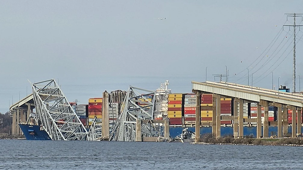 The collapsed Francis Scott Key Bridge lies across the bows of the the container ship 'Dali' that collided with it on 26 March 2024 (photo courtesy @BaltCoFire/X)