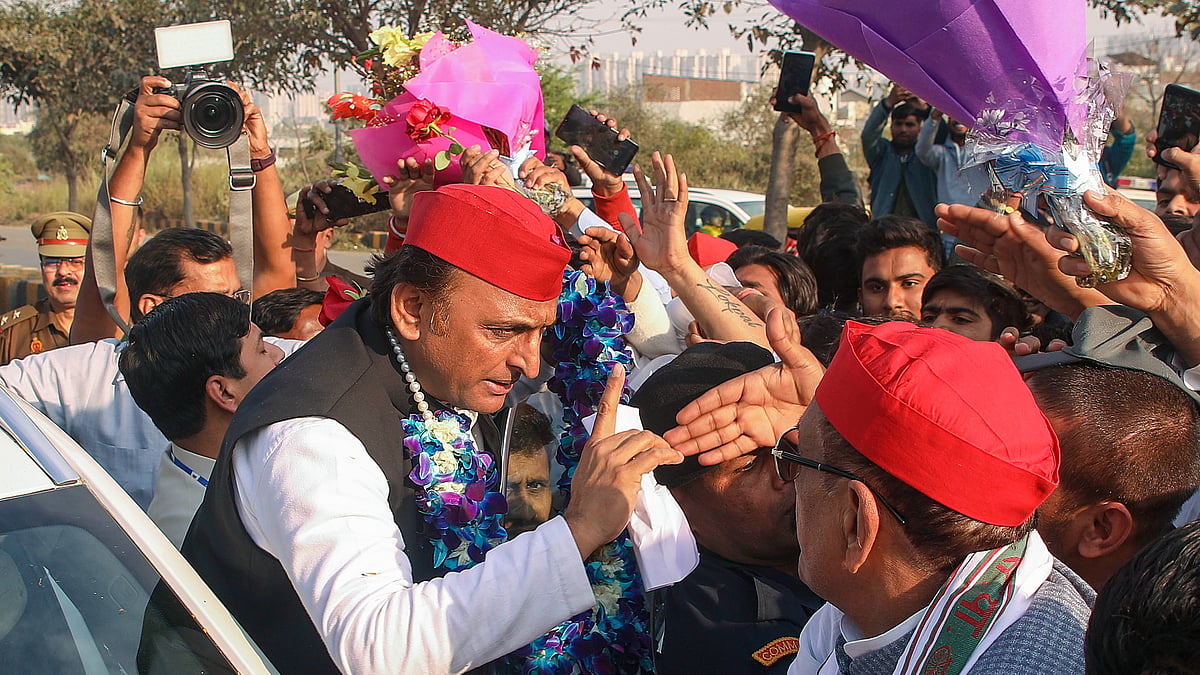 Samajwadi Party president Akhilesh Yadav (in garland and red cap) being welcomed by supporters in Noida, 6 March 2024 (photo: PTI)