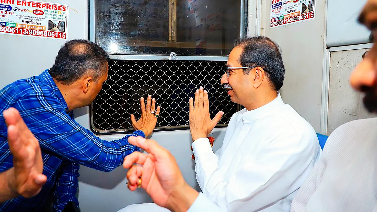 Uddhav Thackeray (right) in a Mumbai local train (photo: PTI)
